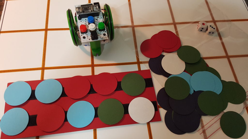 Regleta con velcro sobre la que están adheridos círculos de colores que se corresponden con los movimientos que se introducirán en la botonera del robot.