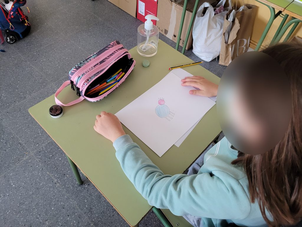 Niña dibujando la pintura rupestre siguiendo las instrucciones recibidas