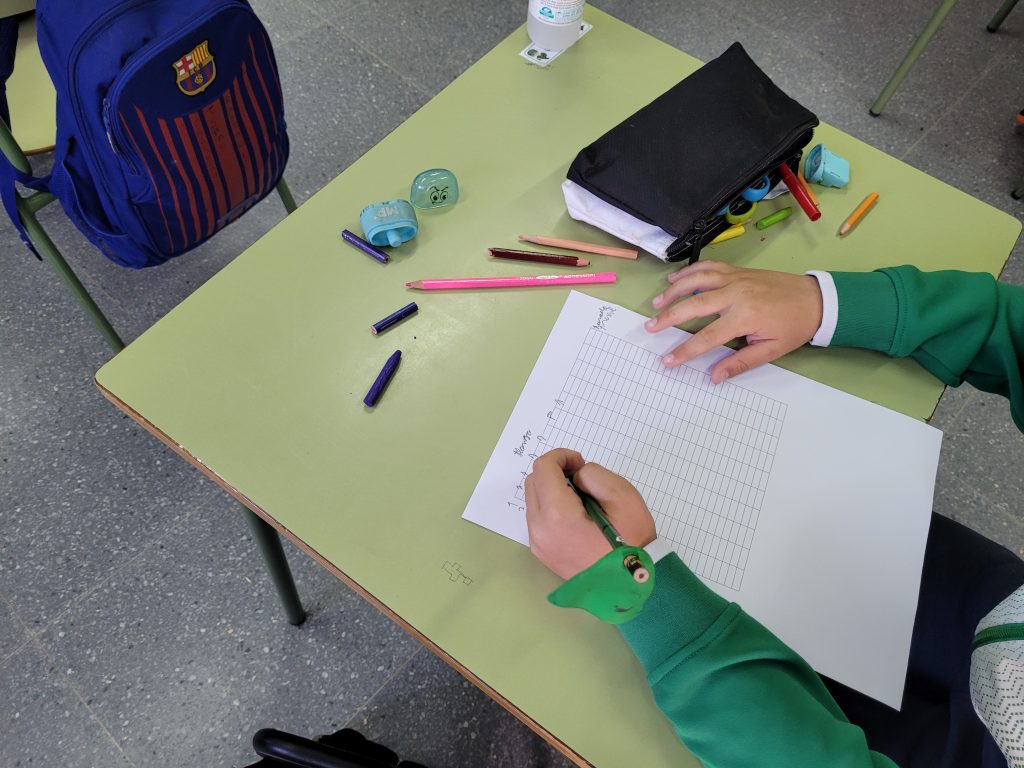 Niño escribiendo en una rejilla de respuestas