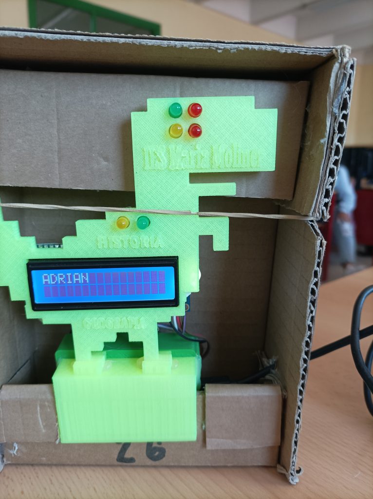 Imagen de un dinosaurio impreso en 3d sobre el que hay instalado varios leds y un pantalla.
