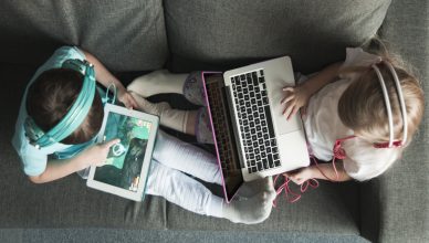 dos niños con dispositivos móviles vistos desde arrilba