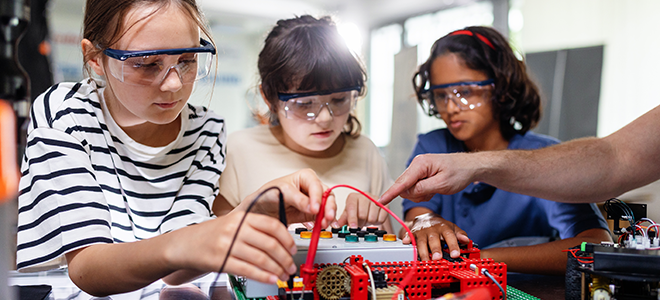 tres alumnas en una clase de robótica y programación