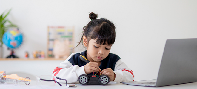 Una niña programando un robot de suelo