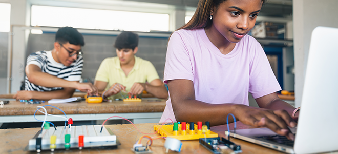 Tres niños en una clase de programación y robótica