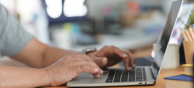 Un hombre escribiendo en su portatil