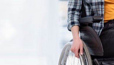 Un niño está sentado en su silla de ruedas y la va empujando