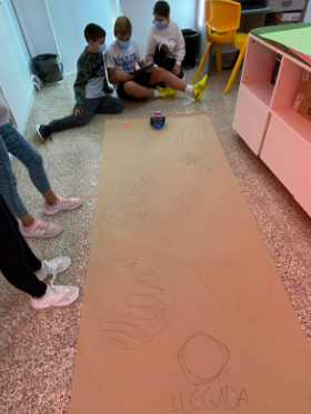 Alumnado practicando con un robot de suelo