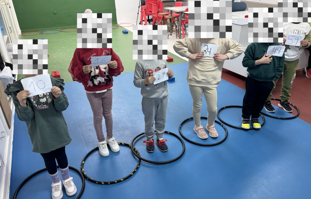 Varios niños y niñas en el AdF jugando con una red de ordenamiento