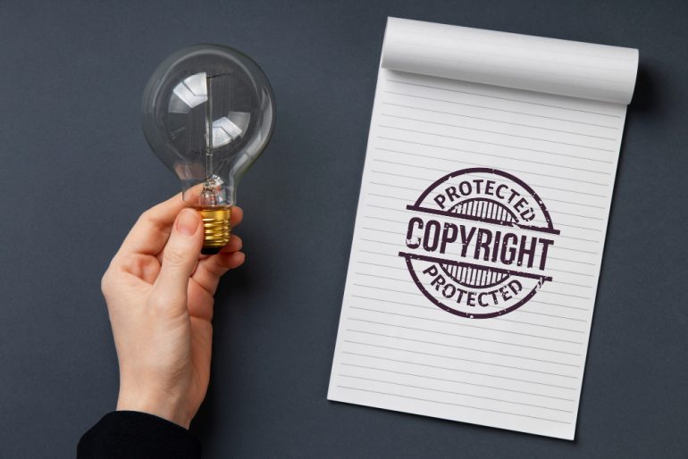 Imagen en la que se ve una bombilla y una libreta con un Copyright